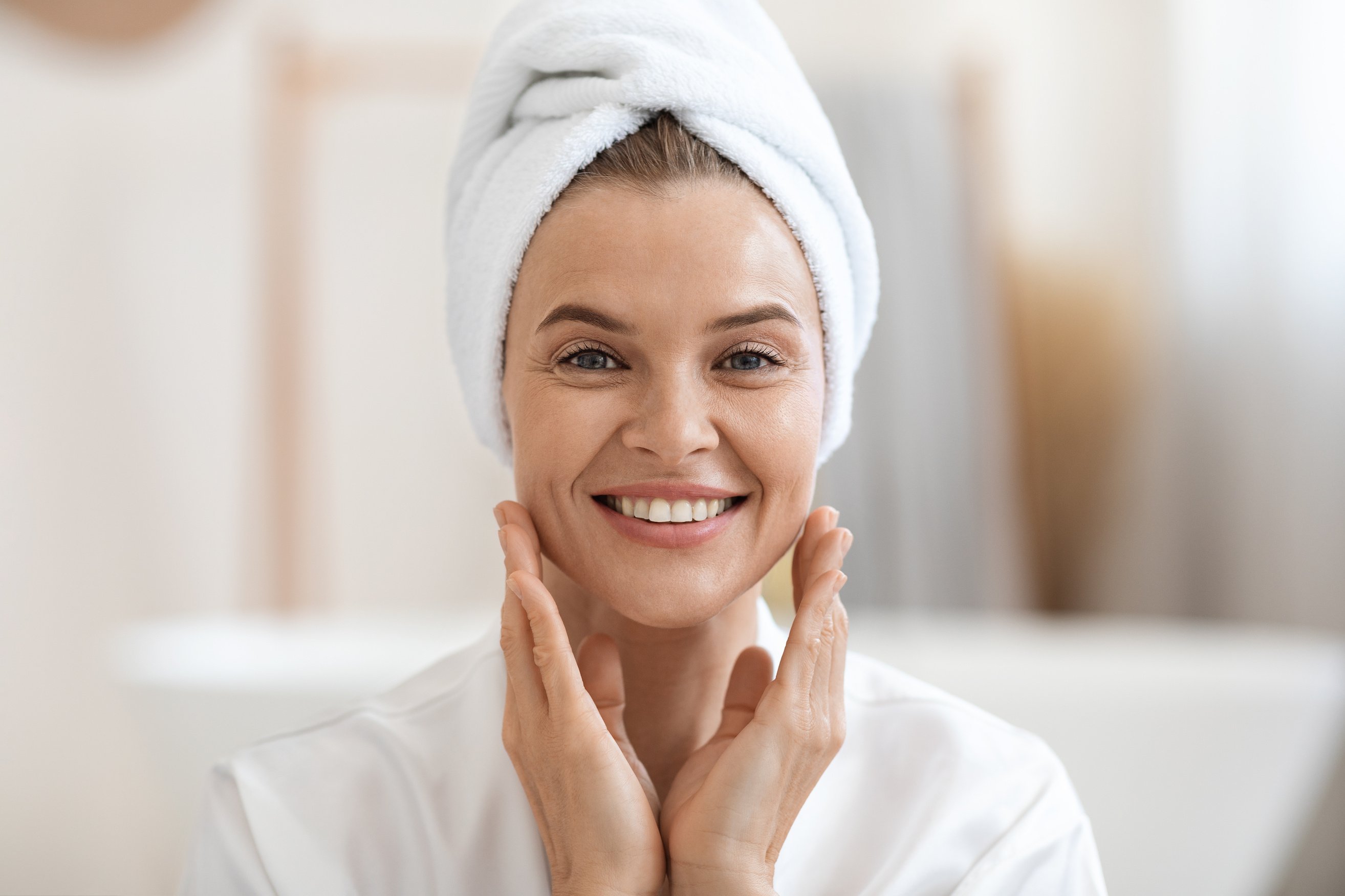 Good-looking woman touching her face and smiling, closeup